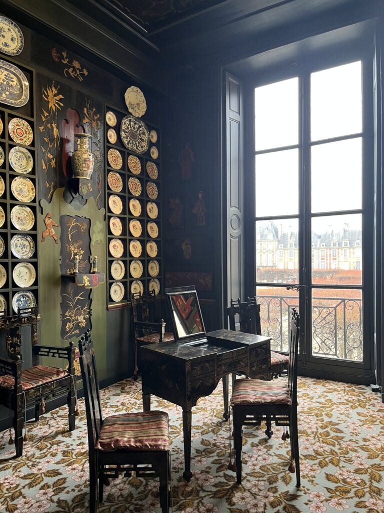 Interior view of Victor Hugo’s apartment in Paris, featuring period furniture, wooden floors, and vintage decor.